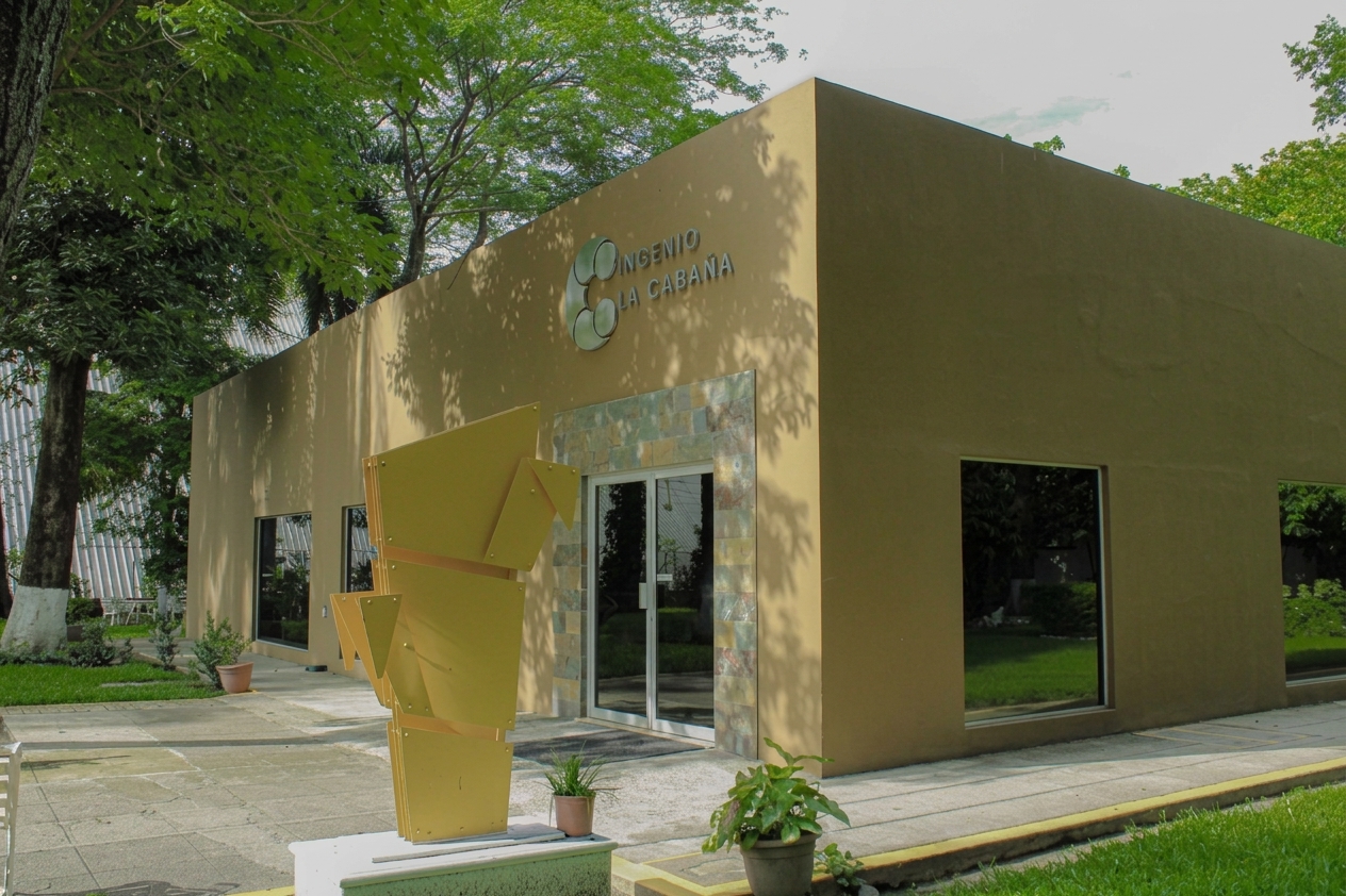Fachada de las oficinas de Ingenio La Cabaña, con el logotipo sobre el muro y jardín al frente