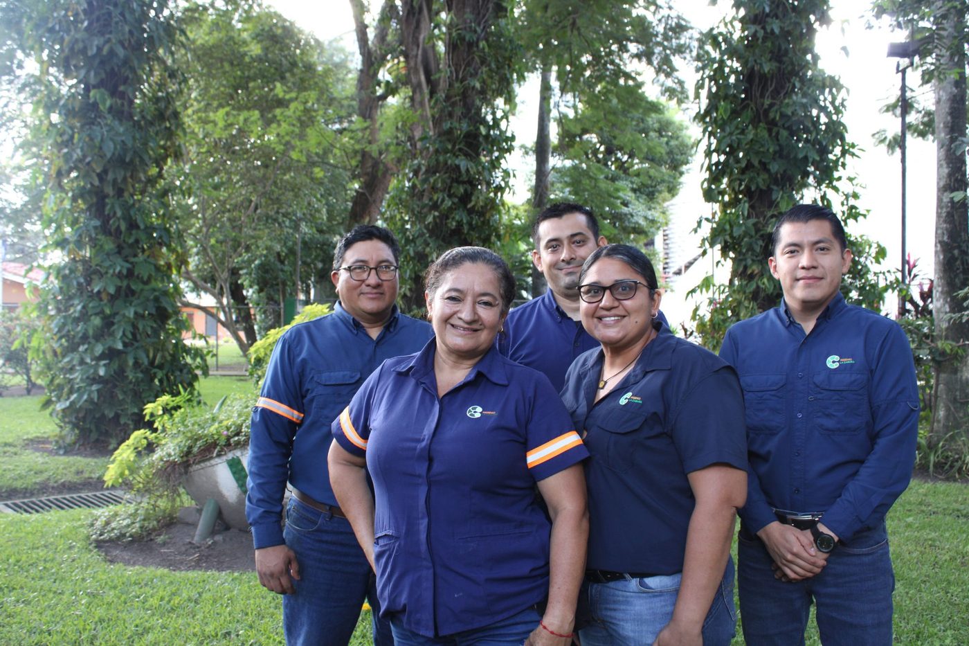 Cinco colaboradores de Ingenio La Cabaña posan juntos en un jardín